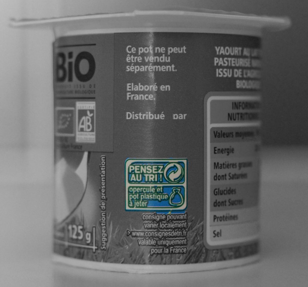 Consigne de tri d'un pot de yaourt en plastique