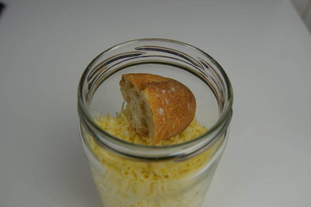 Crouton de pain dans le bocal de fromage râpé